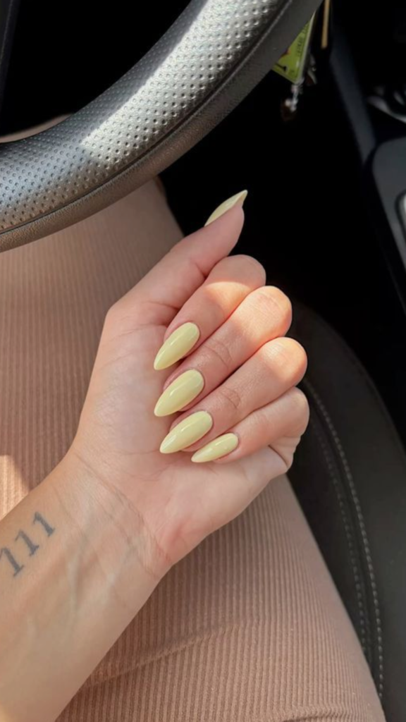 Soft butter yellow manicure on almond-shaped nails perfect for summer 2026.