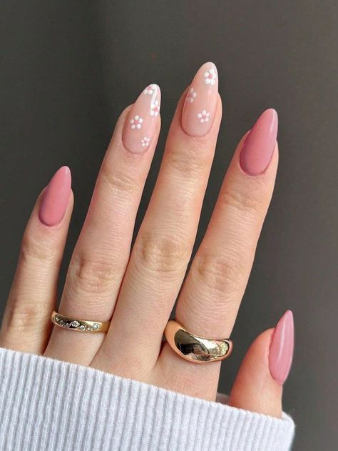 Medium-length almond-shaped nails with a glossy finish, featuring a mix of solid dusty mauve-pink polish on the thumb, index, and pinky fingers, alongside a sheer nude base decorated with small white daisies with mauve centers on the middle and ring fingers.