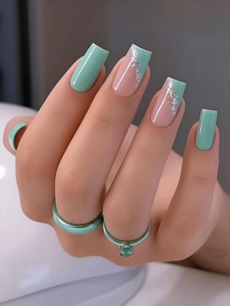 Long square-shaped nails featuring a high-gloss mint green polish on the outer fingers, with the middle and ring fingers showcasing a nude base, a wavy mint green side accent, and a streak of fine silver glitter.