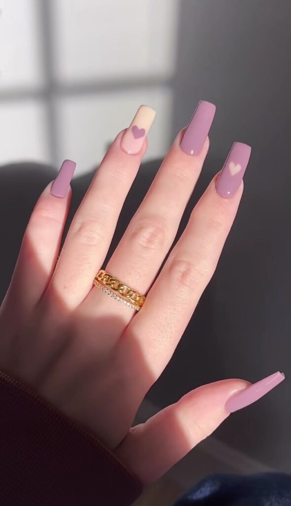 Long matte mauve square nails featuring a cream accent nail with a mauve heart in the center, and a cream heart accent on the index finger.