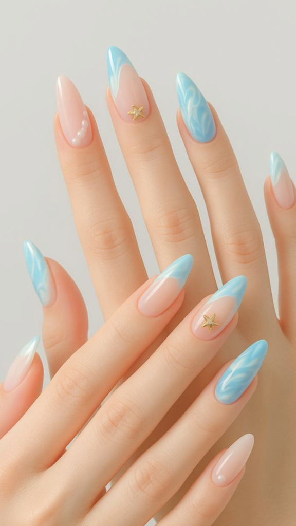 Medium-to-long almond-shaped nails with a glossy finish featuring a beach theme, with a mix of blue ocean wave ripple art, light blue French tips accented with a small gold starfish charm, and nude nails decorated with tiny white pearls.
