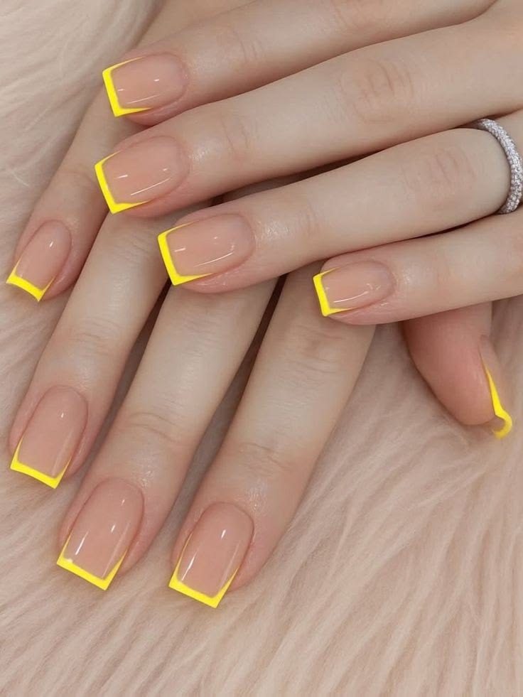 Trendy summer nail design with bright yellow outline French tips and nude base.