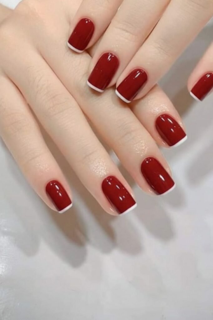 Classic cherry red square nails with thin white micro French tips, creating an elegant and timeless fall manicure.
