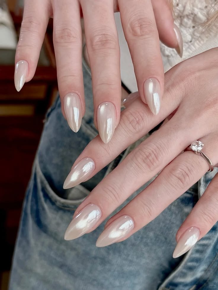 Milky white cat eye nails with a soft pearly magnetic shimmer on glossy almond-shaped nails.