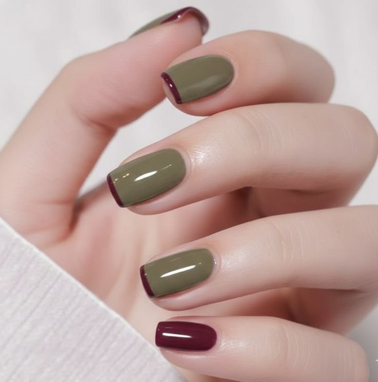 Short olive green square nails with burgundy French tips and a glossy finish, creating a chic autumn-inspired fall manicure.