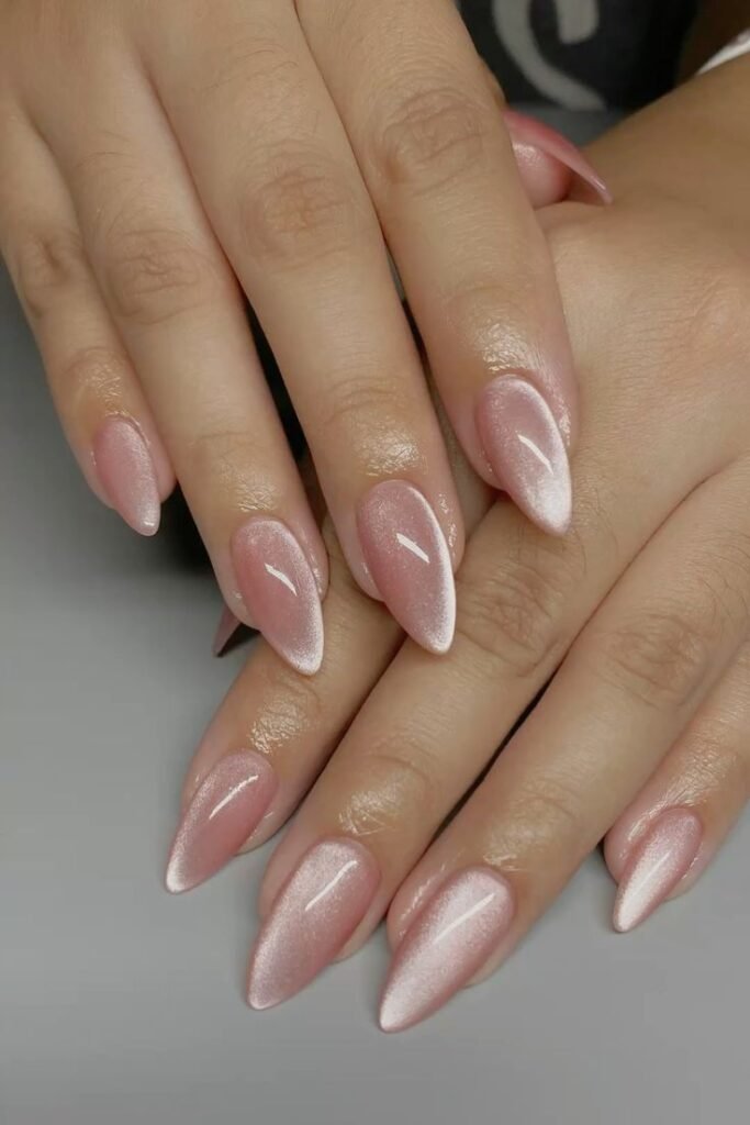 Soft pink cat eye nails with a pearly magnetic shimmer on glossy almond-shaped nails.