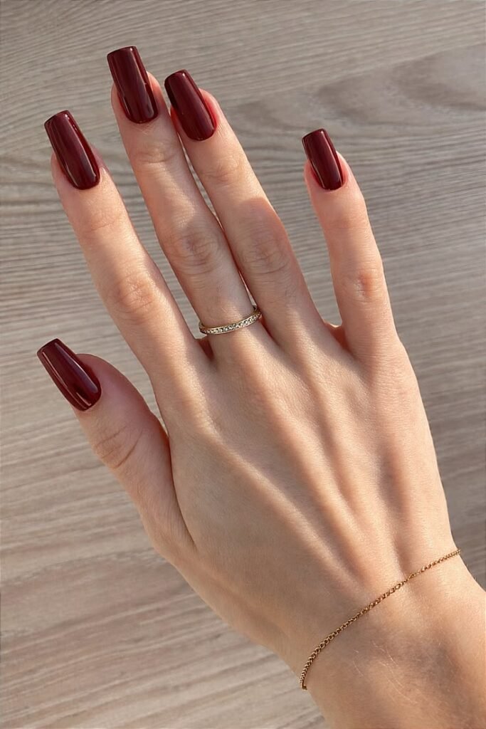 Glossy burgundy square-shaped simple nails ideas
with a minimalist solid color manicure and delicate gold jewelry.