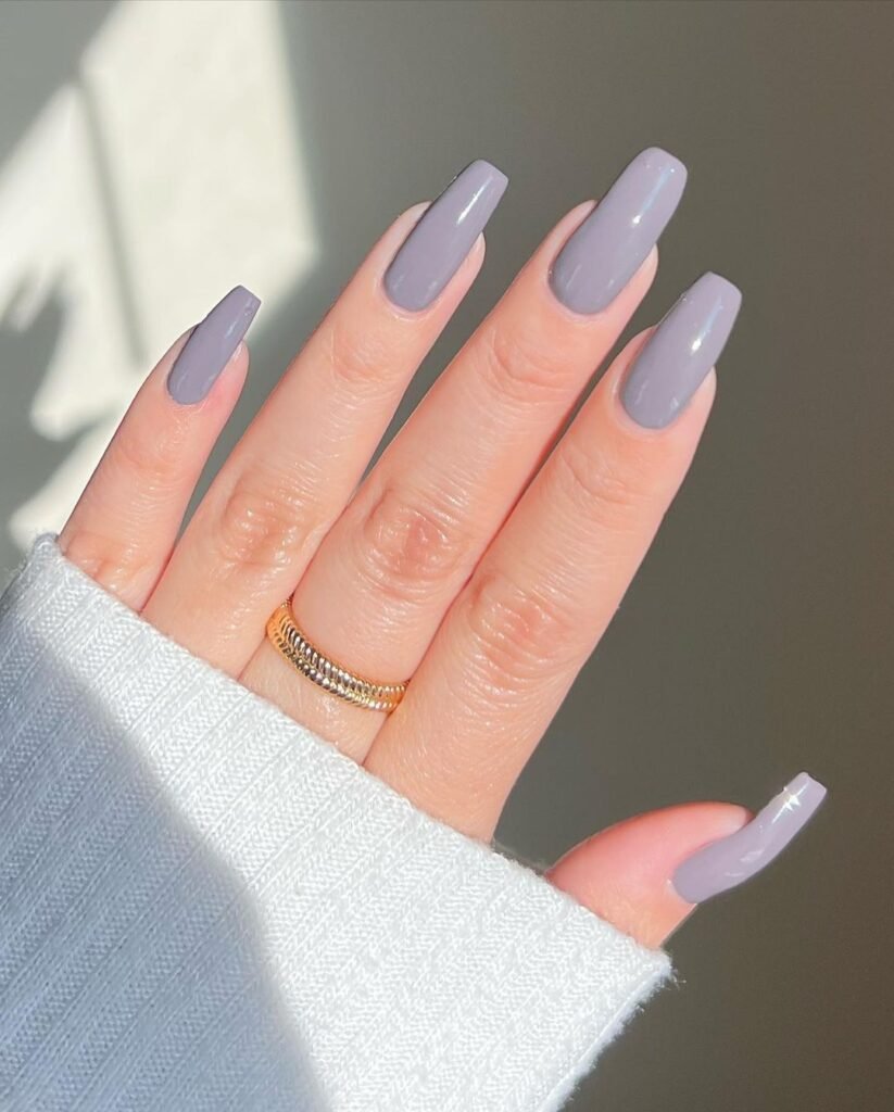 Glossy dusty lavender square-shaped nails with a minimalist solid color manicure and gold ring.