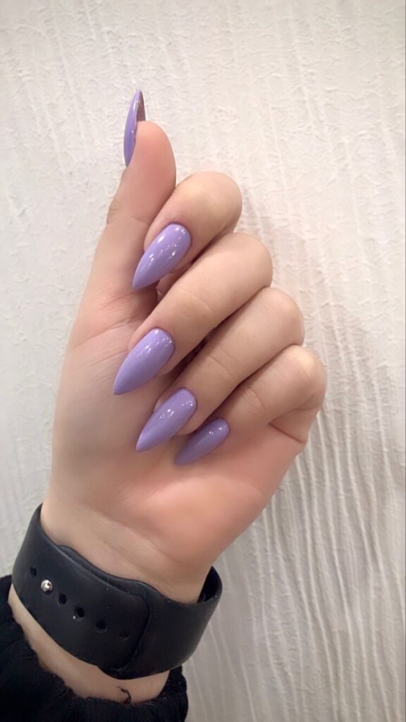 Glossy solid soft lavender almond nails with a smooth gel finish on a feminine hand.