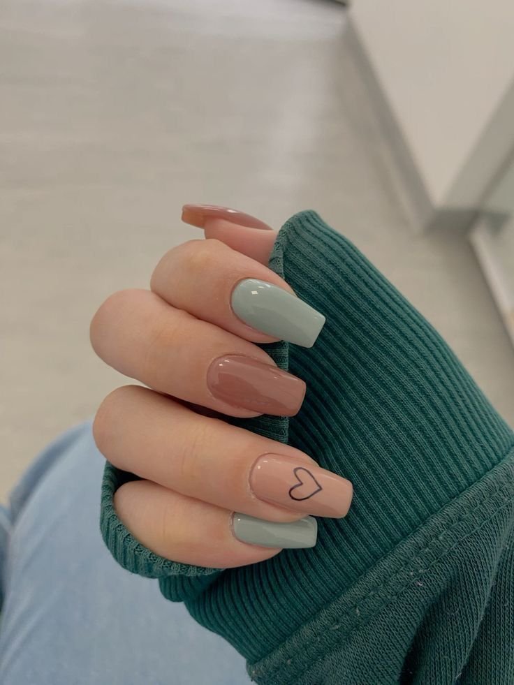 Sage green and dusty rose fall nails with a minimalist black heart outline accent nail, glossy square-shaped autumn manicure, and cozy multi-toned nail art design.