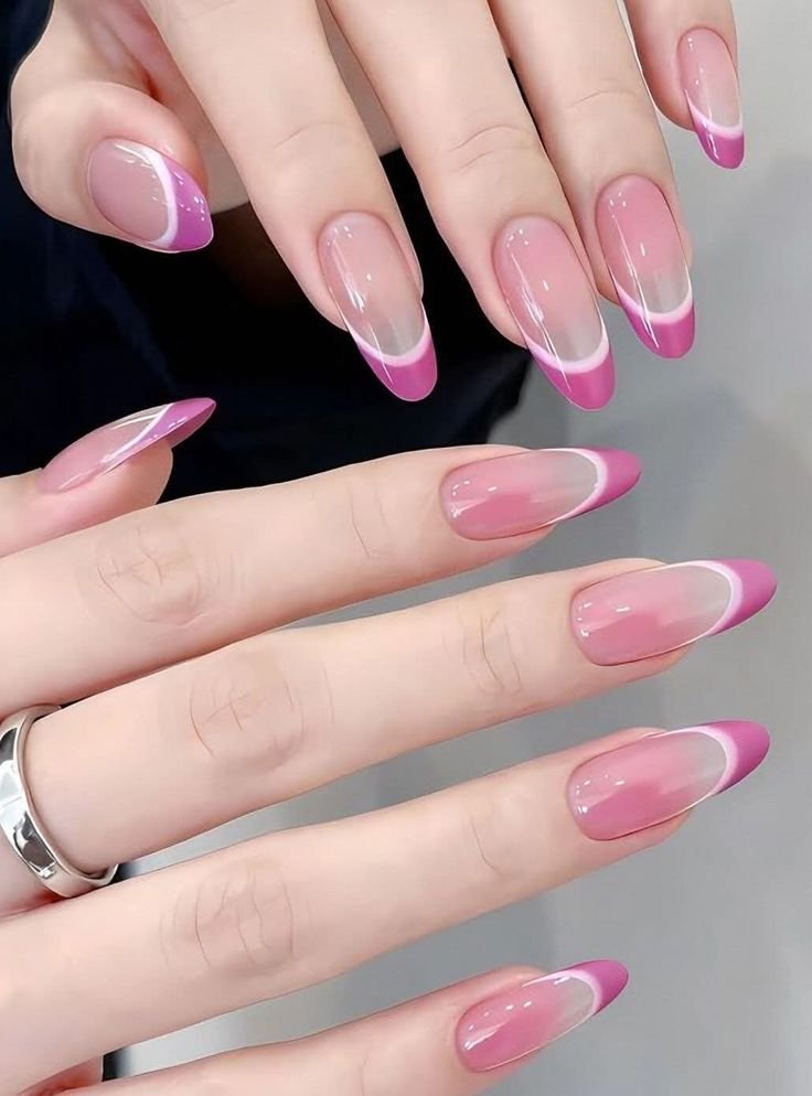 Long oval-shaped nails featuring a sheer blush base with bold orchid-pink French tips paired with a glowing white double magnetic line creating vibrant cat eye nail designs.